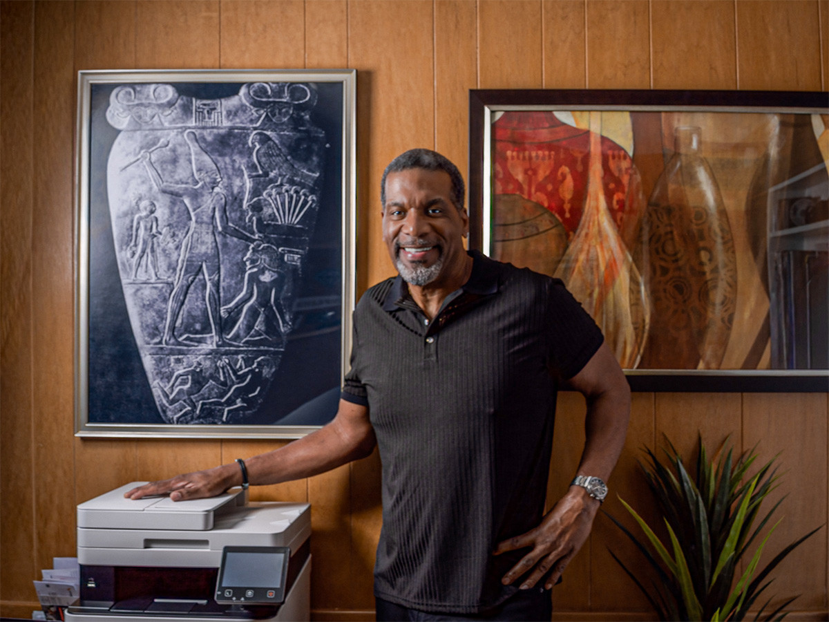 Nkosi Narmer standing next to framed museum photo of the Narmer Palette Nkosi Narmer in his office standing next to the Narmer Palette, the oldest written record of the first sovereign state and oldest recorded empire, symbolizing the deployment of ancient African logic and the unified sovereign mind.